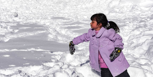 Full length of woman standing on snow covered field