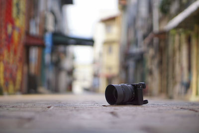 Camera on footpath amidst buildings in city