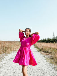 Full length of woman standing on field against clear sky