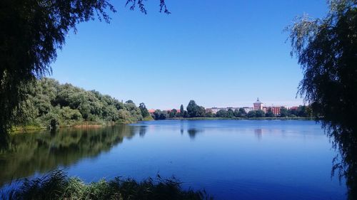 Scenic view of lake against clear blue sky