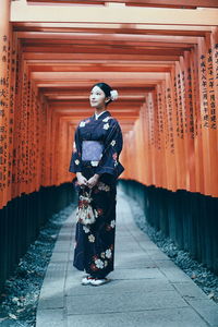 Portrait of woman standing with arms raised