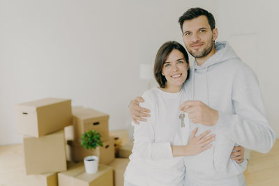 Portrait of couple holding house keys at home