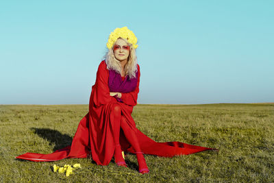 Woman with umbrella on field against sky