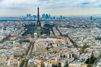 High angle view of city buildings against cloudy sky