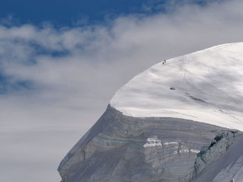 Aerial view of snowcapped mountain against cloudy sky