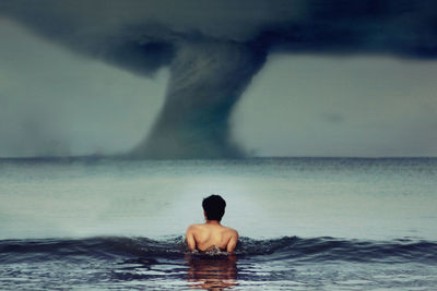 Rear view of man in front of sea