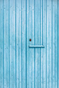 Texture of an old wooden door painted blue in greece