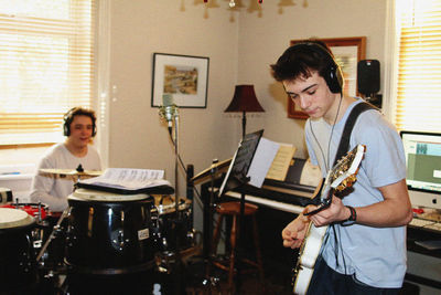 Young men playing music while practicing at home