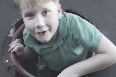 Close-up portrait of smiling boy sitting outdoors