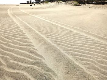 High angle view of tire tracks on sand dune