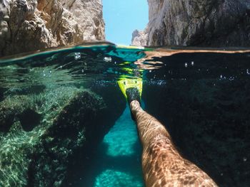 Low section of man swimming in sea