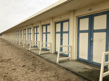 View of empty beach by building against sky