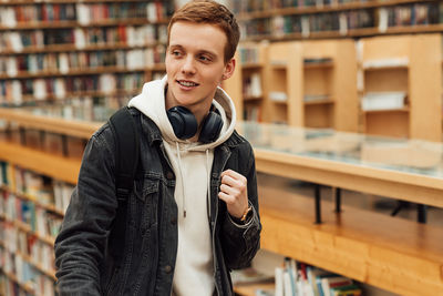 Portrait of young woman standing in library