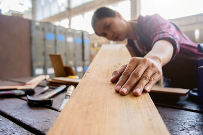 Midsection of carpenter working at workshop