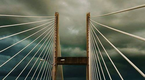 Low angle view of suspension bridge against sky