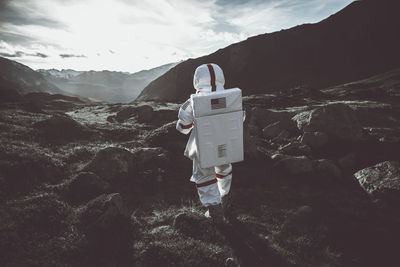 Man standing on rock against mountains