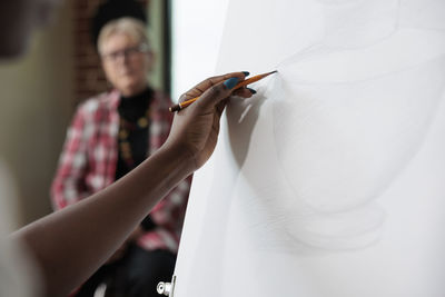 Hand of woman sketching on canvas