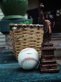 Close-up of baseball with statue of liberty sculpture