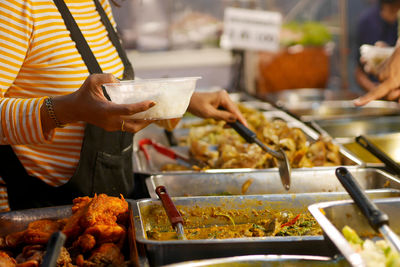 Midsection of man preparing food on barbecue grill