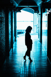 Side view of woman walking in corridor