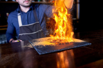 Man with fire on table