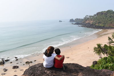 Rear view of woman sitting on beach