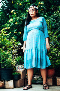 Portrait of a beautiful young woman standing in flower pot