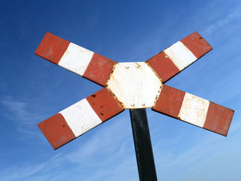 Low angle view of warning sign against blue sky