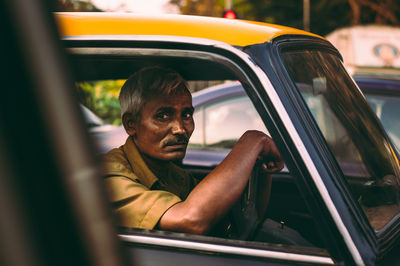 Portrait of man sitting in car