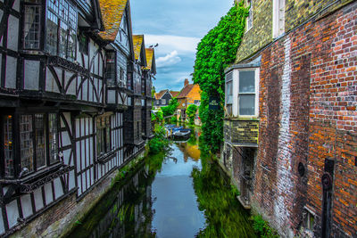 Canal amidst buildings against sky