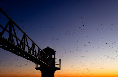 Low angle view of bridge against sky during sunset
