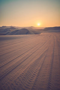 Scenic view of desert against sky during sunset