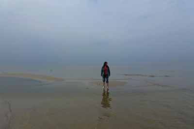 Rear view of woman walking on beach