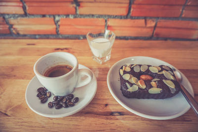 High angle view of coffee cup and dessert on table