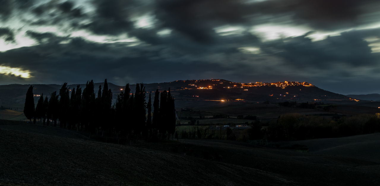 PANORAMIC SHOT OF ILLUMINATED CITYSCAPE AGAINST SKY