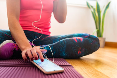 Low section of woman using mobile phone at home