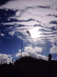 Low angle view of silhouette flag against blue sky