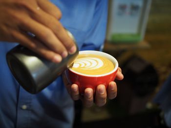 Close-up of hand holding coffee cup