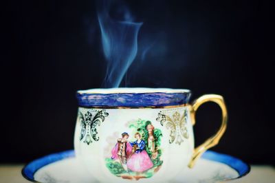 Close-up of tea cup against black background