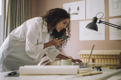 Young woman using mobile phone at home