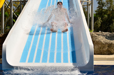 Full length of man enjoying on slide at water park