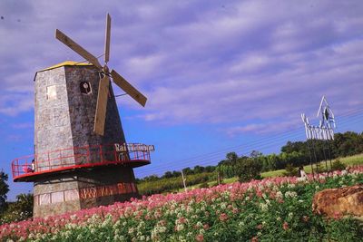 Traditional windmill on field against sky