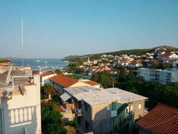 High angle view of townscape by sea against clear sky