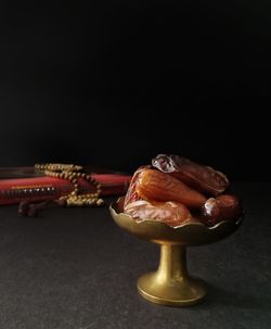 Close-up of cake on table against black background