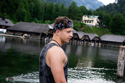 Side view of man wearing sunglasses standing by lake