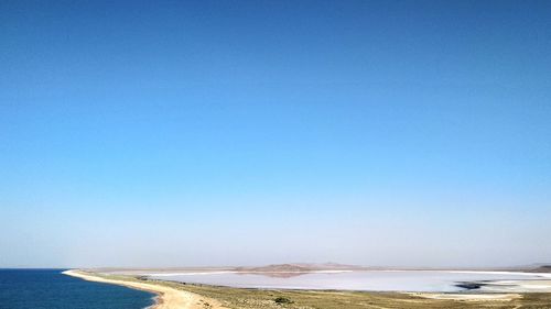 Scenic view of beach against clear blue sky