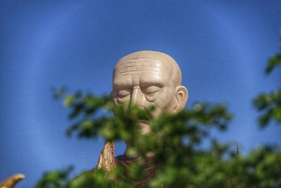 Close-up of statue against blue sky