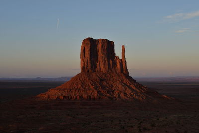 Rock formations on landscape against sky during sunset