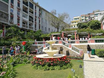 People in swimming pool against buildings in city