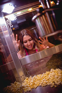 Smiling woman standing by popcorn maker